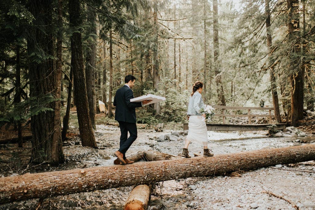 bride and groom hiking through the woods in washington