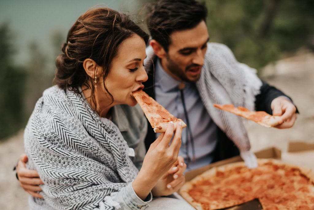 bride and groom eating pizza