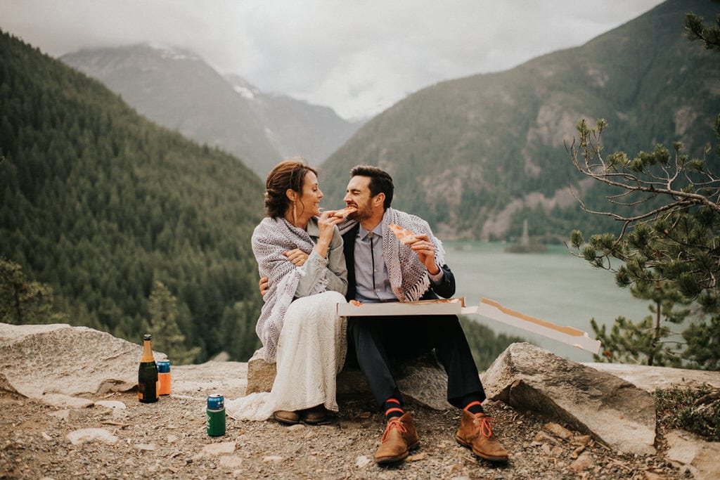 bride feeding groom pizza after gorgeous mountain elopement