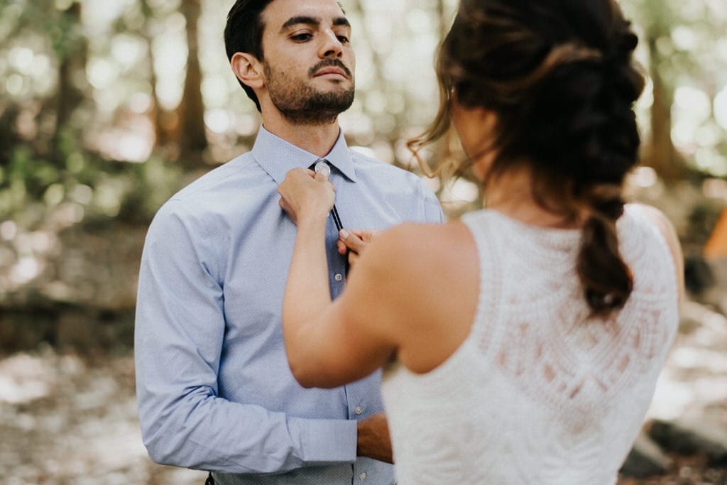 bride putting on grooms bolo tie