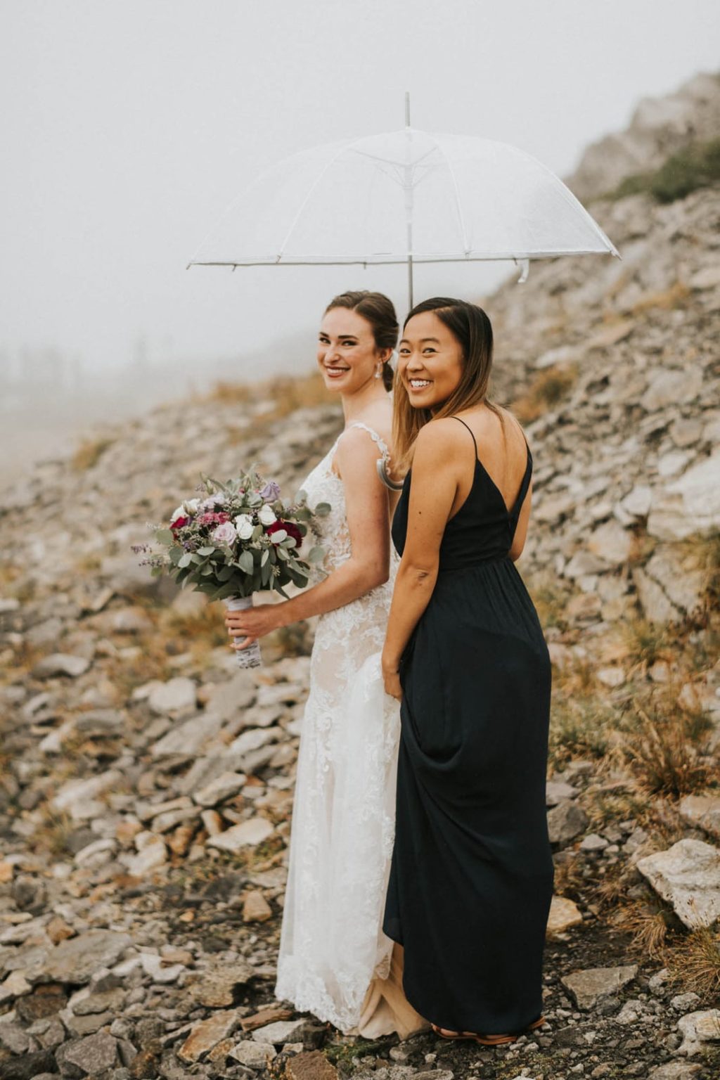 bride and bridesmaid standing together smiling