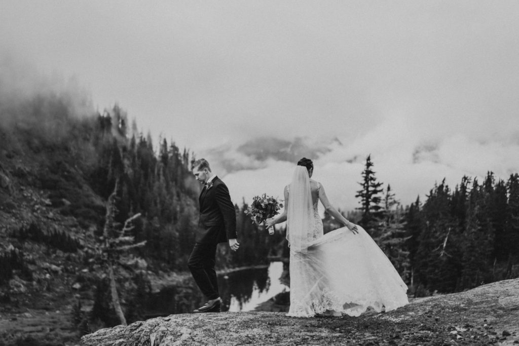 black and white of bride and groom on cliffside