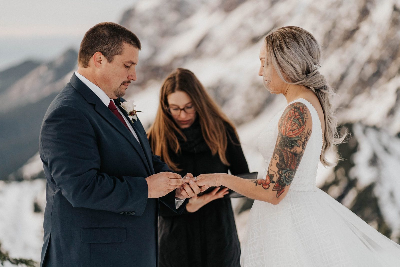 groom putting ring on bride at ceremony